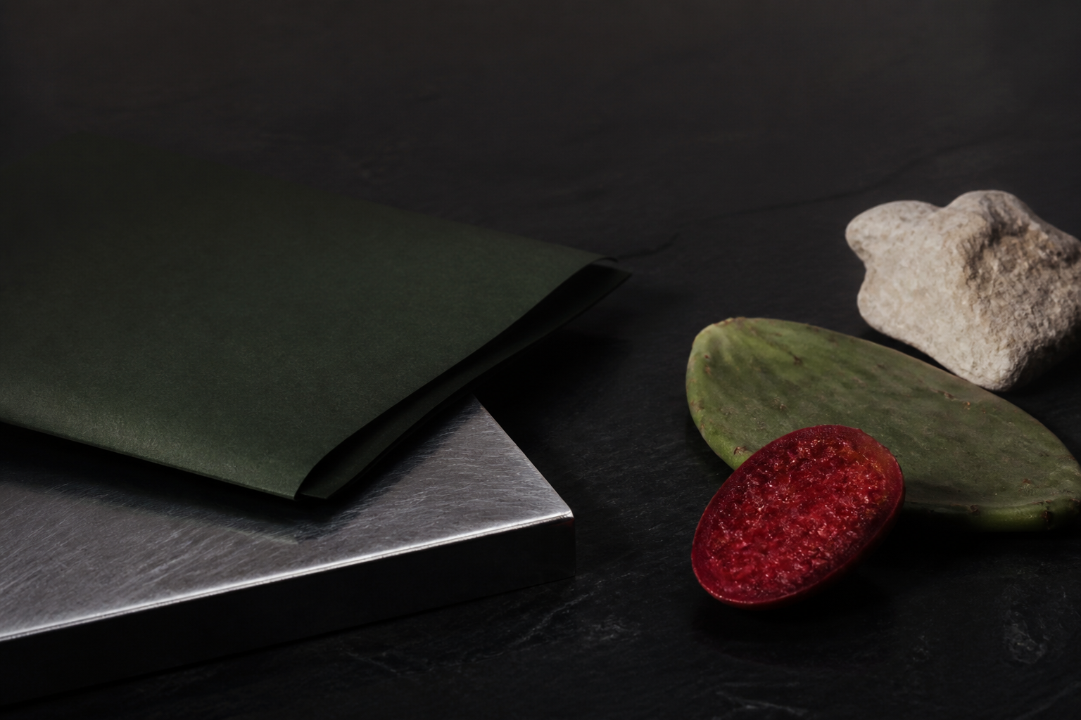 Beles private bottle window file with folded dark-green paper, silver metal, nopal, prickly pear and stone