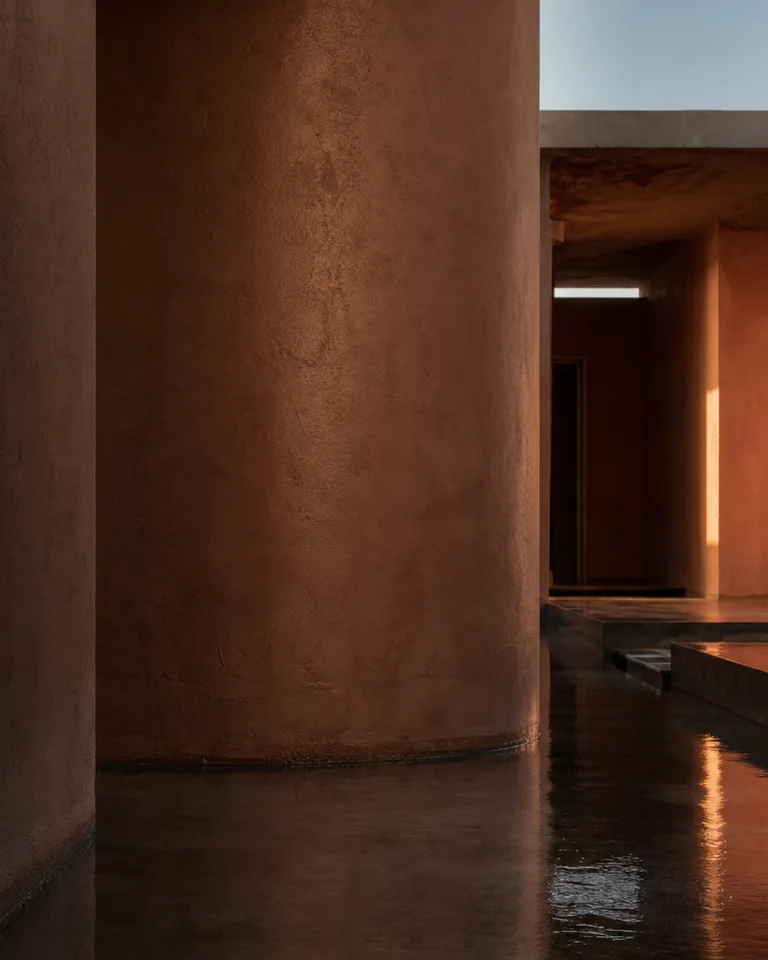 Warm amber resin and reflected copper light on dark mineral stone.