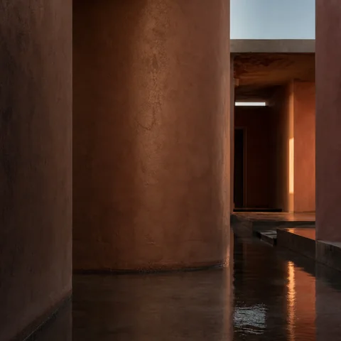 Warm amber resin and reflected copper light on dark mineral stone.