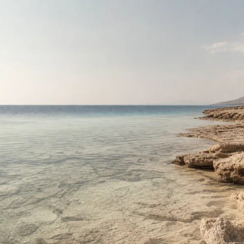 Blue water, pale stone and salt haze in a conceptual coastal material study.